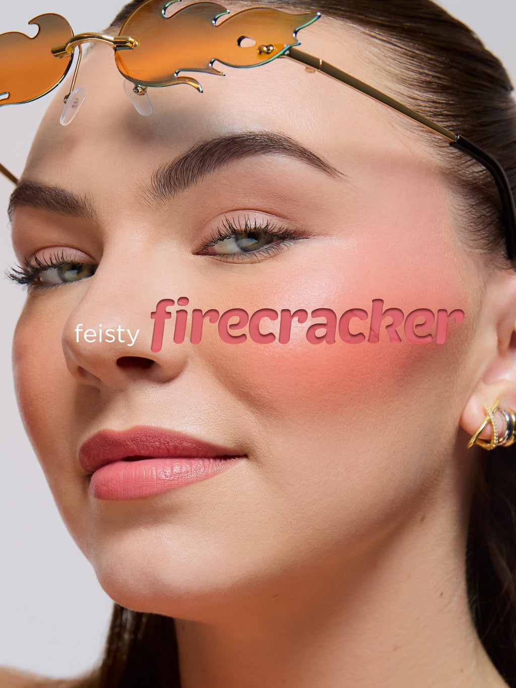 Close-up of a woman's face with 'feisty firecracker' text overlay, wearing gold sunglasses.