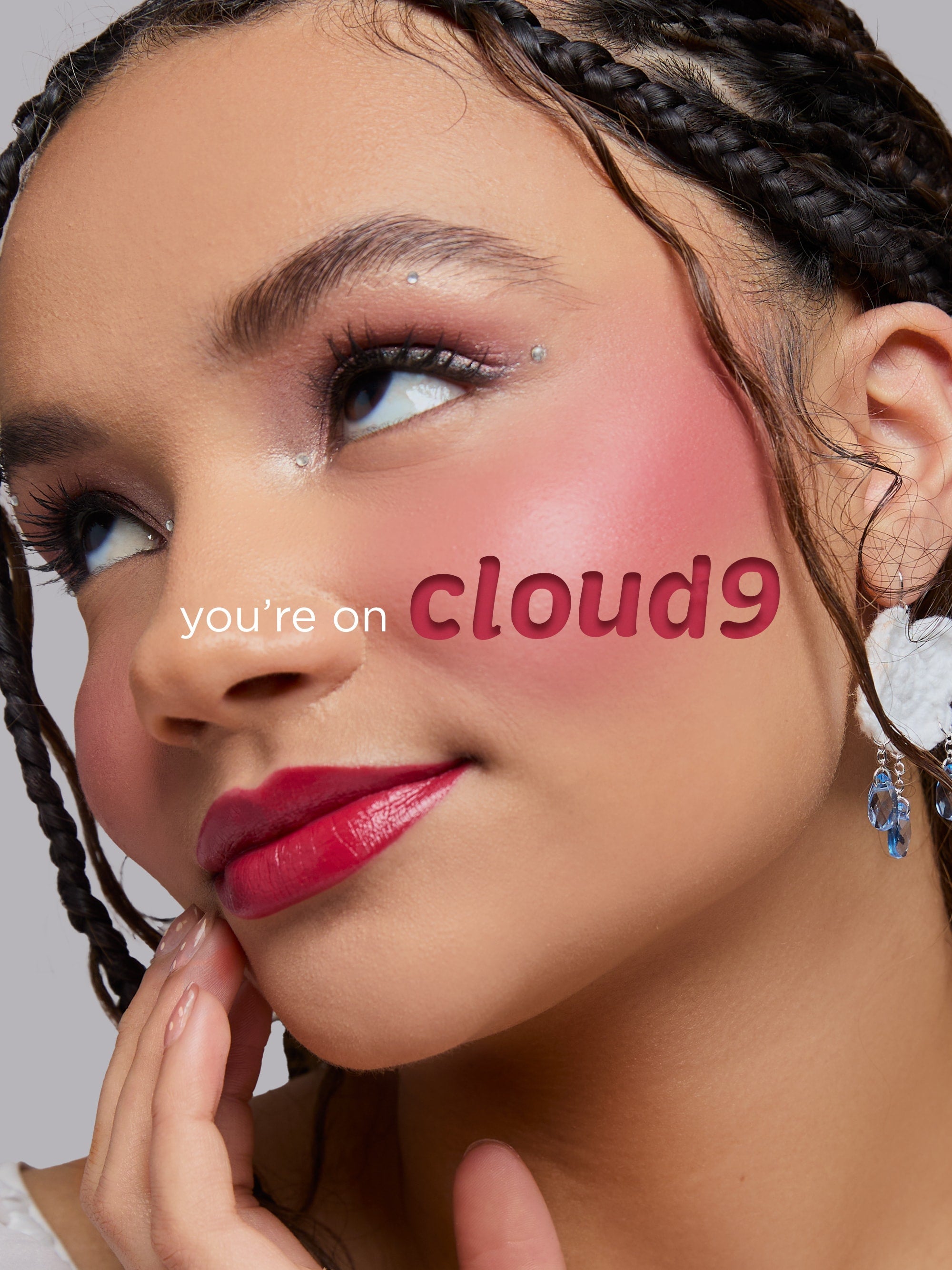 Woman with 'you're on cloud9' text on her cheek against a neutral background