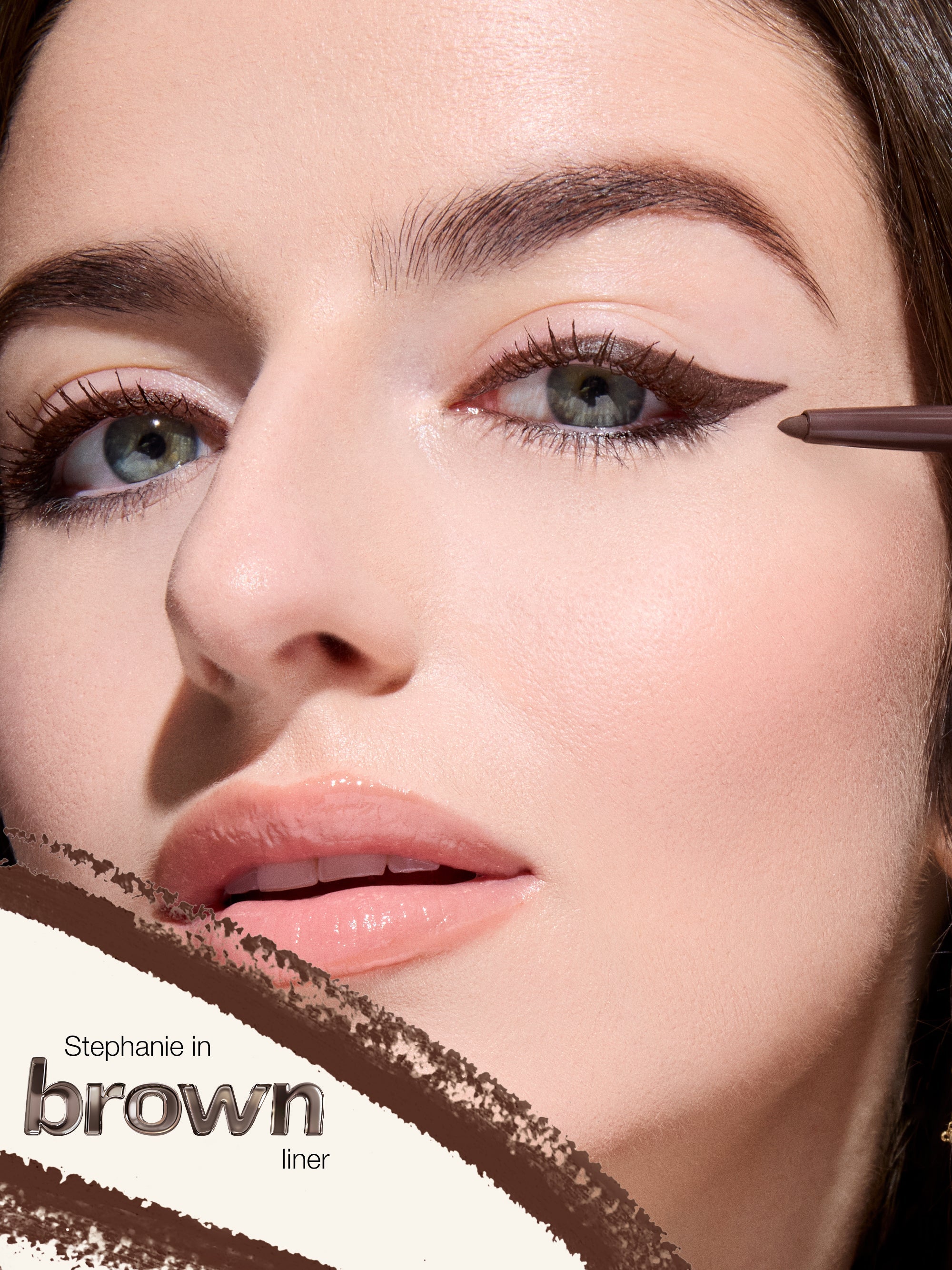 Close-up of a woman applying brown eyeliner with a brush.