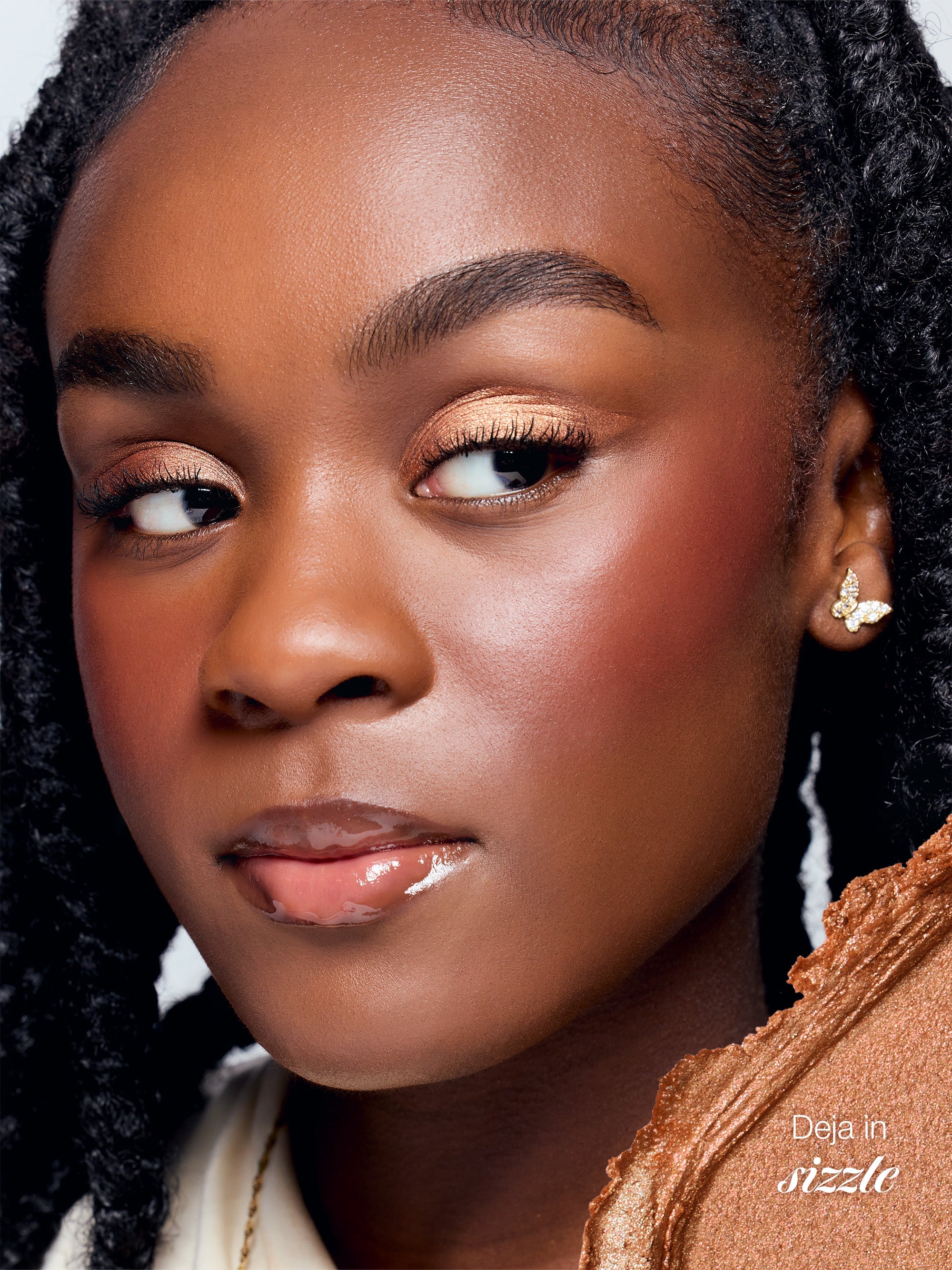 Close-up of a woman's face with makeup, wearing an earring, against a neutral background.