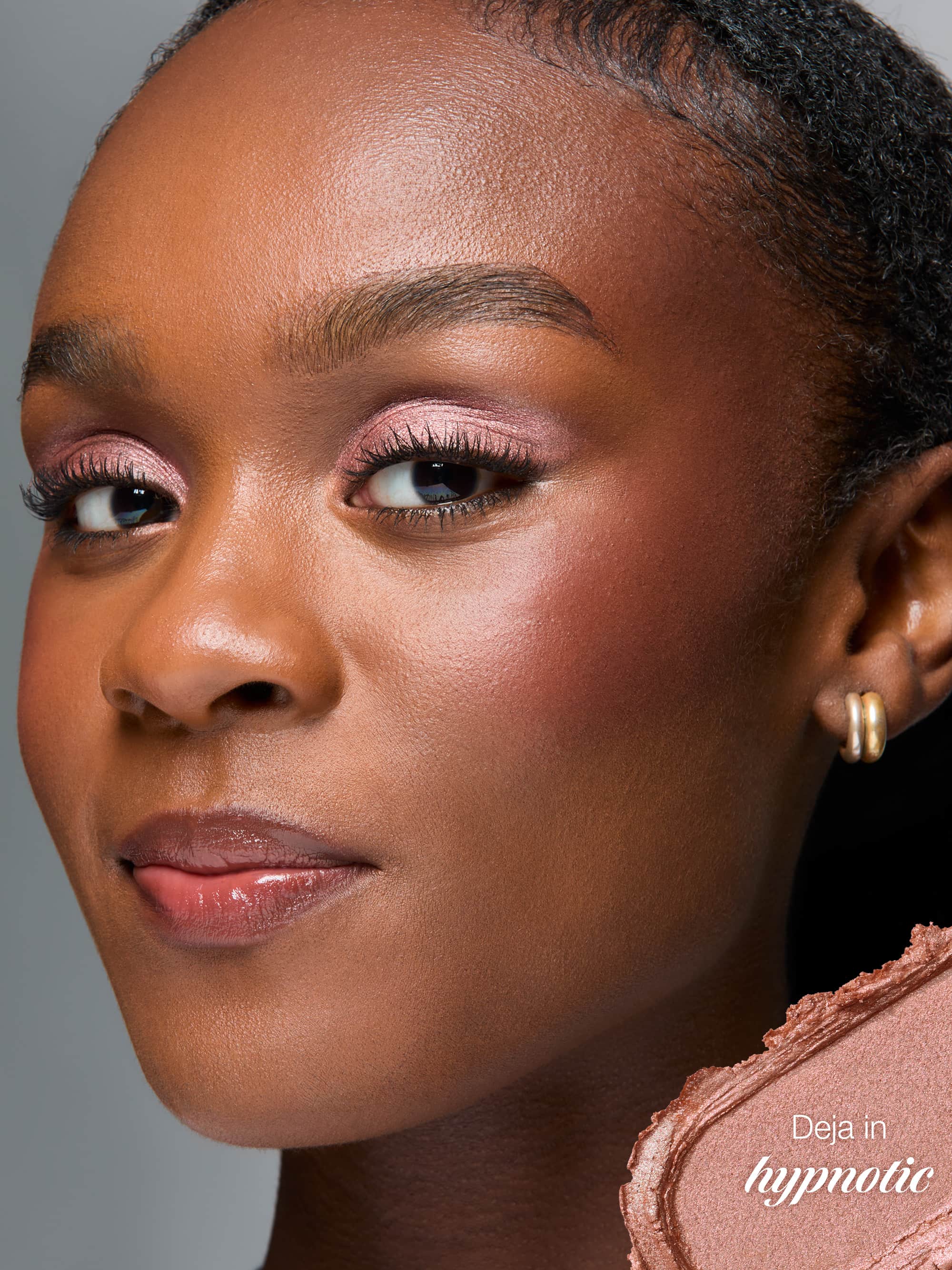 Close-up of a woman's face with makeup product in the corner