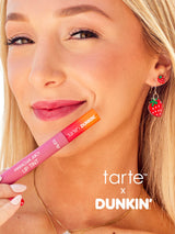 Woman holding a tarte x Dunkin' lip tint with visible branding