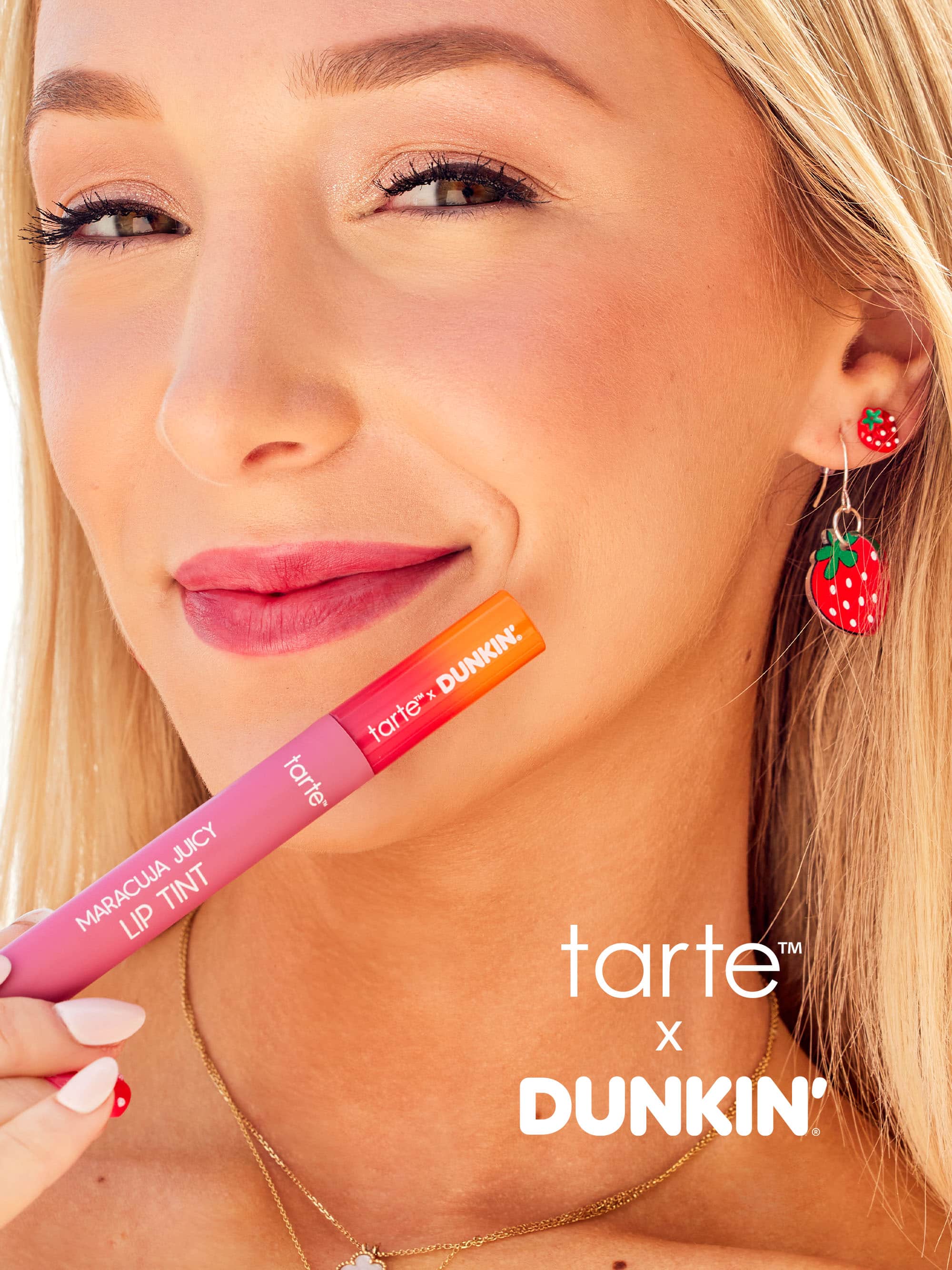 Woman holding a tarte x Dunkin' lip tint with visible branding