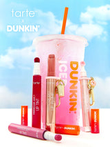 Tarte x Dunkin' lip products and a pink drink with an orange straw against a blue sky background.