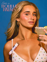 Woman holding a cocktail with tarte maracuja juicy double ended multi stick  text on a blue background