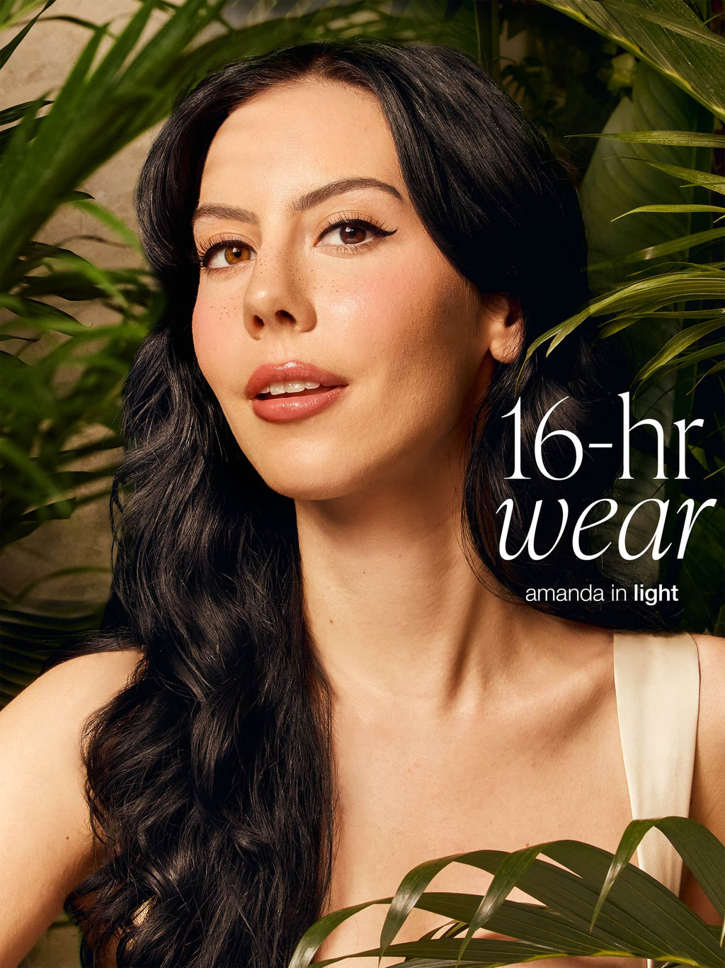 Woman with long dark hair surrounded by greenery with text '16-hr wear' and 'amanda in light' wearing tarte CC serum 