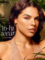 Woman wearing a tan cami with '16-hour wear' text and plant background wearing tarte CC serum 