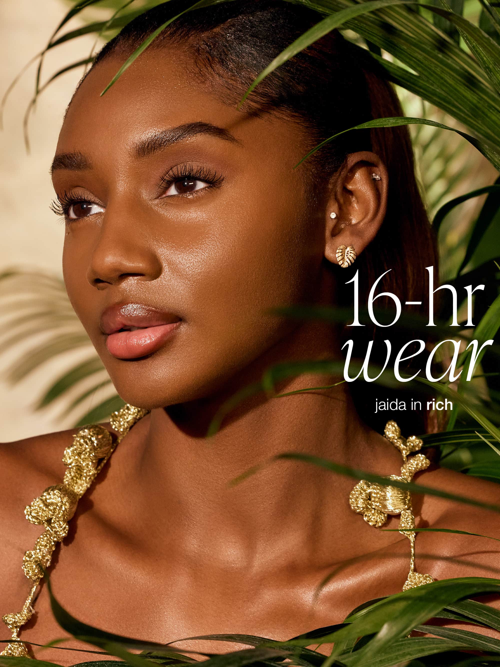 Woman wearing gold jewelry with text '16-hr wear' and 'jaida in rich' against a leafy background wearing tarte CC serum 