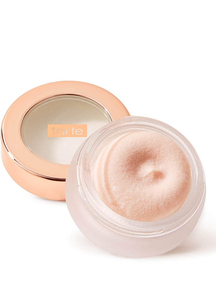 Cosmetic cream in a round container with a rose gold lid on a white background