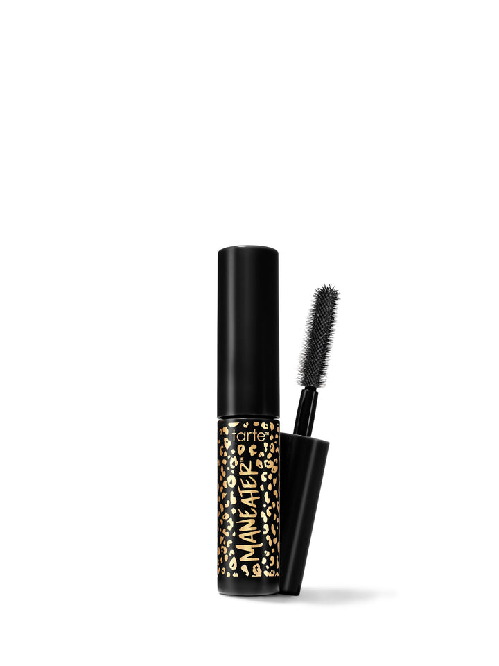 A travel-size mascara with a black tube and a brush applicator, featuring a gold and black pattern on the tube.