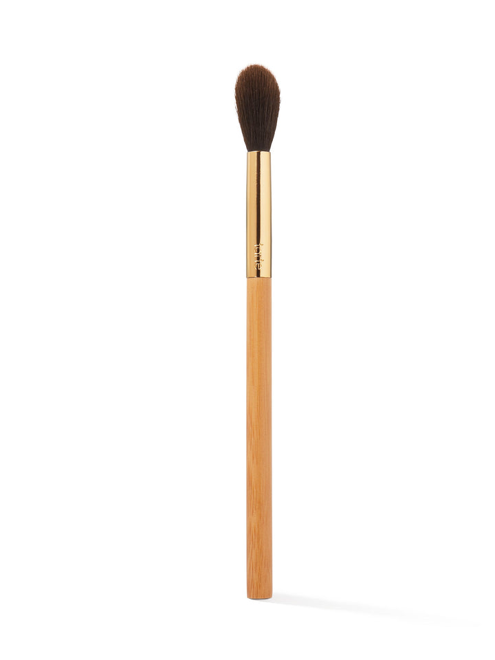 Makeup brush with brown bristle head and gold ferrule on a white background