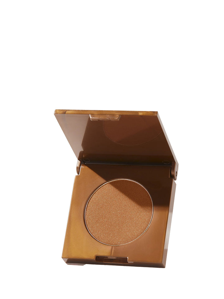 Bronze-colored compact powder in a clear case on a white background
