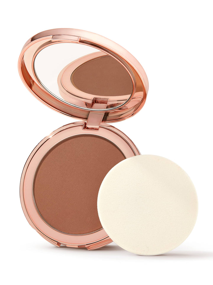 Compact bronzer with rose gold case and white powder puff on a white background