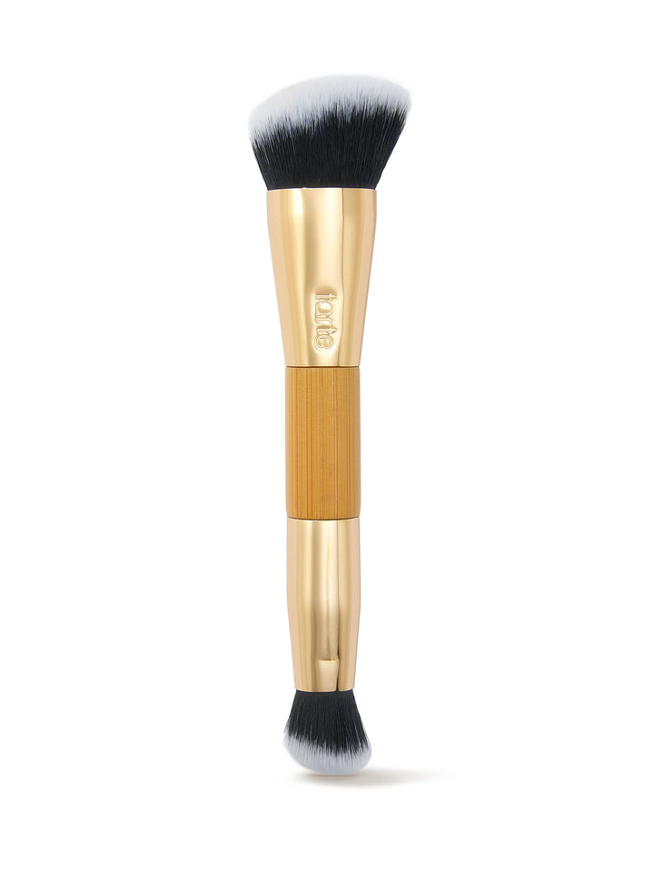 Makeup brush with gold handle and black bristles on a white background