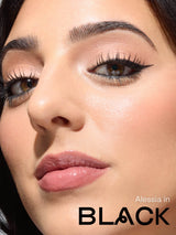Close-up of a woman's face with makeup application, specifically eyeliner, with 'Alessia in Black' branding.