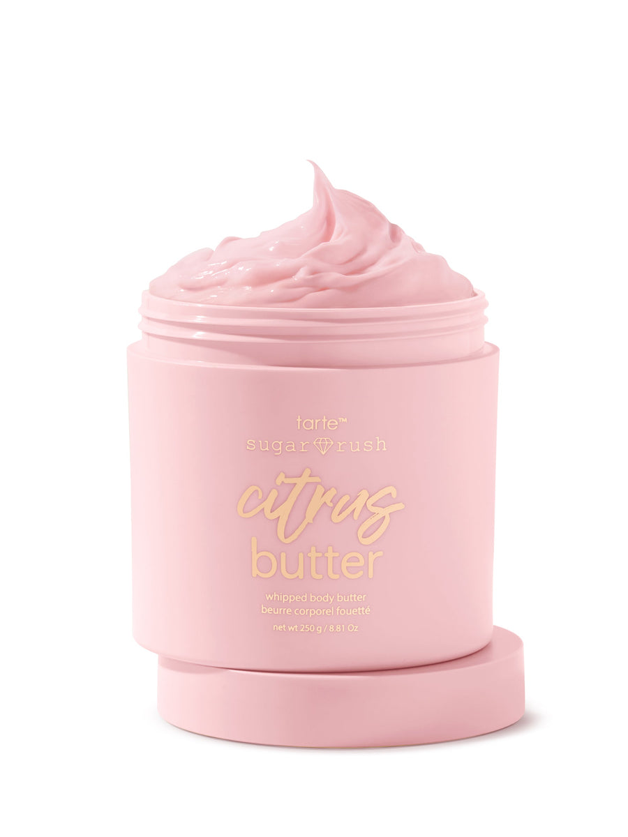 Pink jar of 'citrus butter' body scrub with visible brand name on a white background