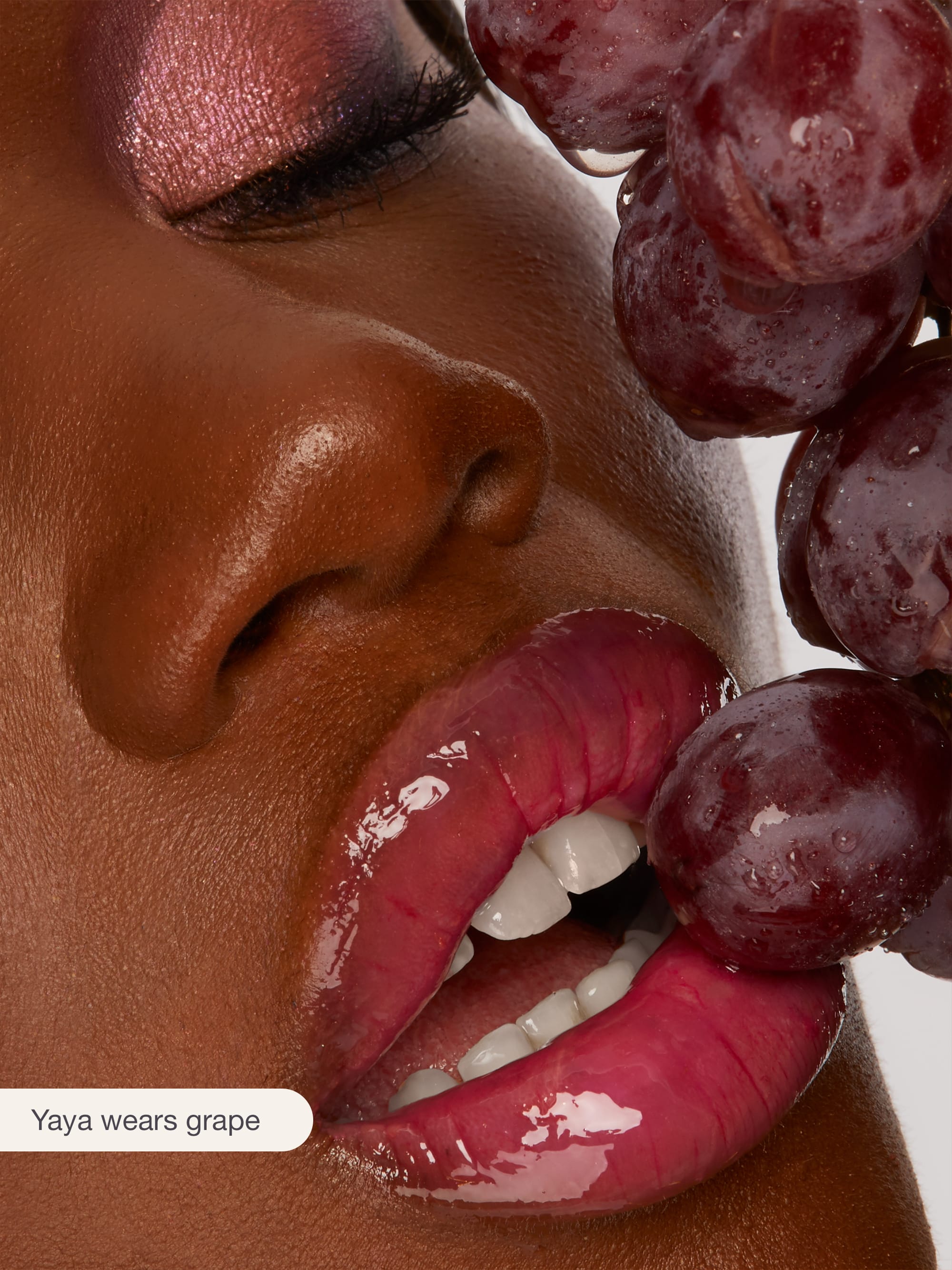 Close-up of a person with grapes near their face, with 'Yaya wears grape' text.