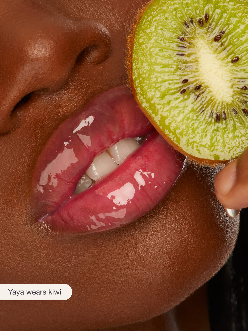 Close-up of a person holding a sliced kiwi near their mouth with 'Yaya wears kiwi' text.